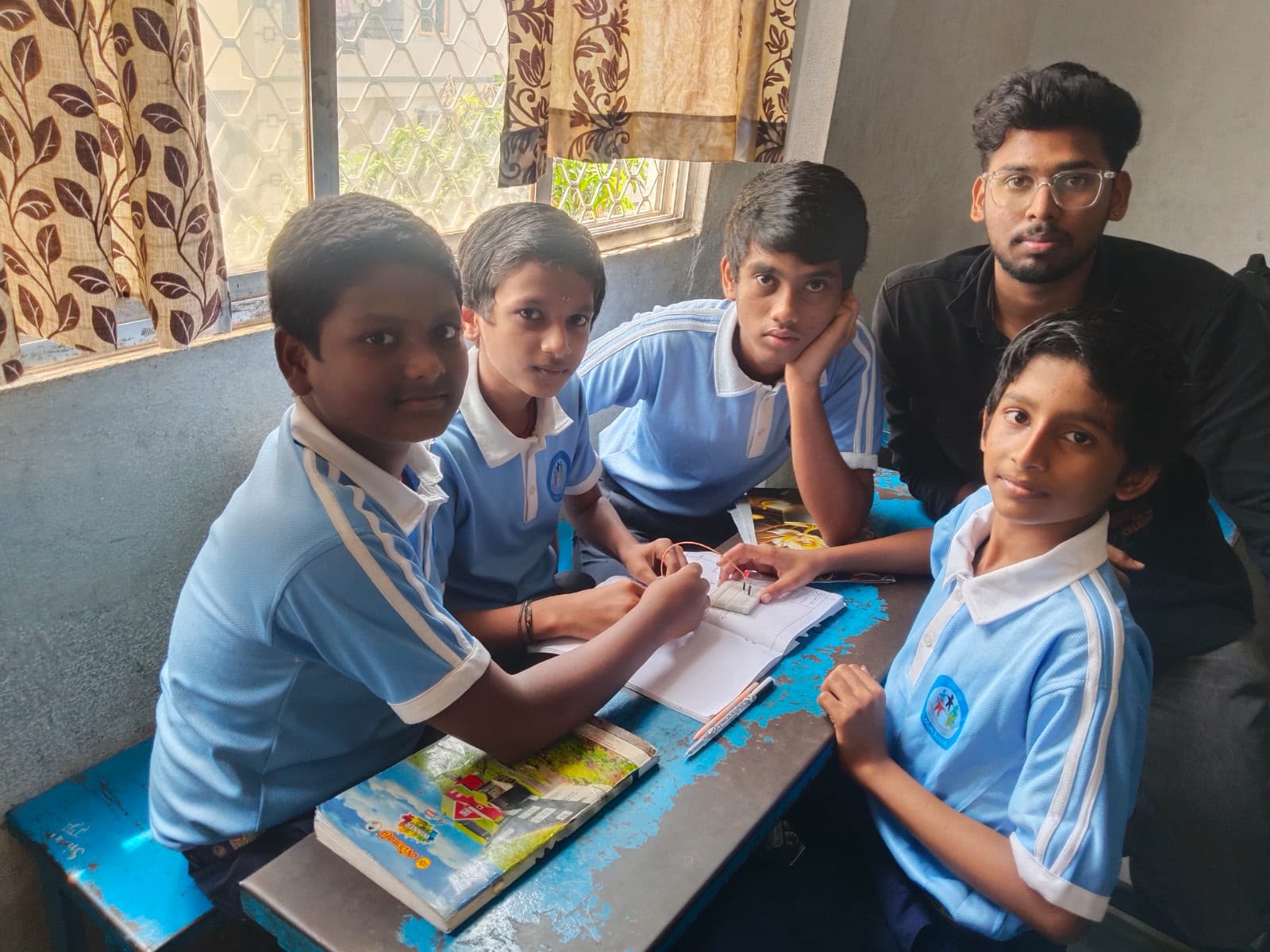 Students and a trainer collaborating on an electronics circuit